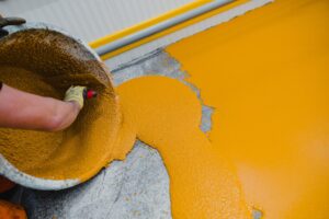 Worker applying epoxy and polyurethane flooring system